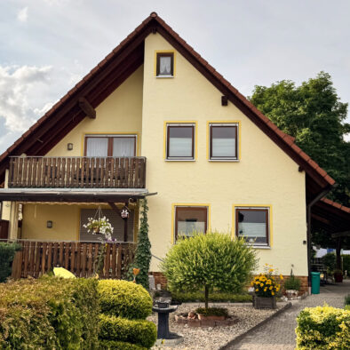 Ferienwohnung Weiher – Außenansicht des Hauses mit Balkon und gepflegtem Garten in Schwanstetten