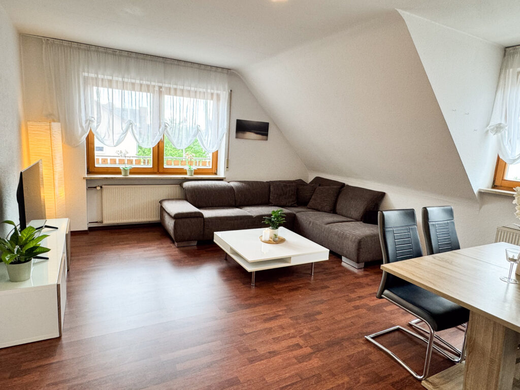 Wohnzimmer mit Couch und Fernseher – Ferienwohnung Weiher